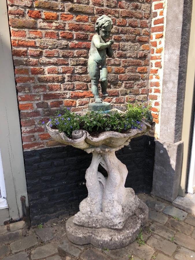Old fountain with bronz putti on concrete base.